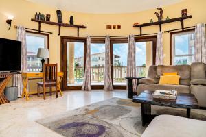 a living room with a couch and a tv at Residences at Barrier Reef 3B Oceanview 2 BR by Stay Floreo in San Pedro