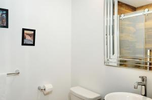 a white bathroom with a toilet and a sink at 102 chemin des Ruisselets in Stoneham +7 photos