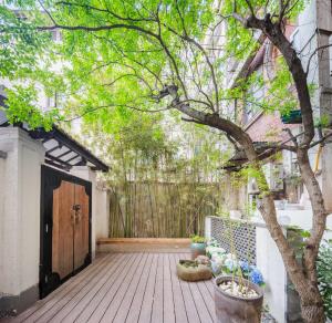 una terraza de madera con un árbol frente a un edificio en Tonight Aparthotel West Nanjing Road Shanghai, en Shanghái