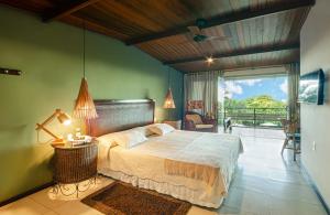 a bedroom with a large bed and a balcony at Hotel Ponta do Madeiro in Pipa