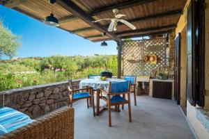 a patio with a table and chairs and a stone wall at Caletta Nest 88 in Porto Rotondo