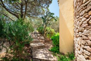 a stone pathway with a bench next to a building at Caletta Nest 88 in Porto Rotondo