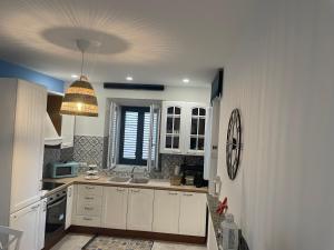 a kitchen with white cabinets and a ceiling at Casa 99 in Amendolara