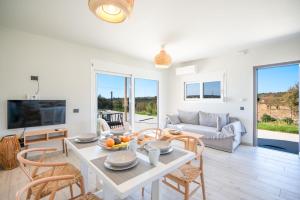 un soggiorno con tavolo, sedie e divano di Villa Katerina Mentoros a Karavádhos