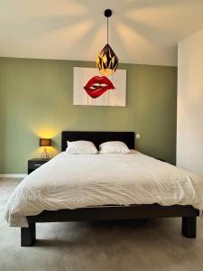 a bedroom with a large bed with a chandelier at La Terrasse Urbaine Epinal in Épinal