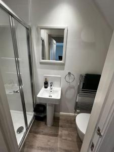 a bathroom with a toilet and a sink and a shower at Neptune House The Bay Filey Home Sweet Holiday Homes with car ev point in Filey