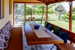 a wooden table with a bowl on it on a porch at Seven Heaven Seaside Cottage in Makri