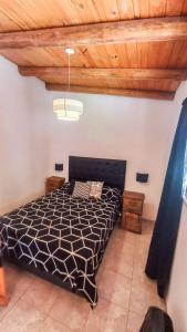 a bedroom with a bed and a wooden ceiling at Monoambiente amplio con pileta in Cosquín