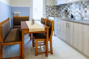 a kitchen with a table and chairs and a sink at Stefias Apartment in Kallithéa