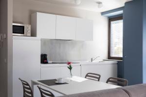 a white kitchen with a table and chairs and a microwave at CHARMING MOMENT di Villa Porta - Residenza Ortensia in Luino