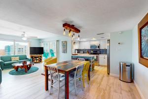 a kitchen and living room with a table and chairs at Anglers Cove 602 in St. Pete Beach