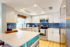 a kitchen with white cabinets and a white counter top at Anglers Cove 602 in St. Pete Beach