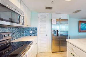 a kitchen with a stainless steel refrigerator and blue walls at Anglers Cove 602 in St. Pete Beach