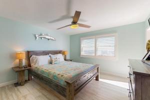 a bedroom with a bed and a ceiling fan at Anglers Cove 602 in St. Pete Beach +14 photos