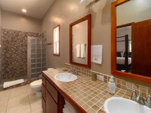 a bathroom with two sinks and a toilet and a mirror at Residences at Barrier Reef 16A Garden View 1 BR by Stay Floreo in San Pedro