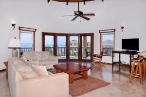 a living room with a couch and a table and a television at Residences at Barrier Reef 8C Oceanview 2 BR by Stay Floreo in San Pedro