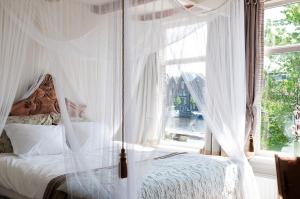 a bedroom with a canopy bed with a window at RiverSide Suite - Haarlem City Centre in Haarlem
