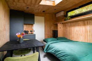a bedroom with a bed and a table and a window at Boshuisje Zelhem in Zelhem