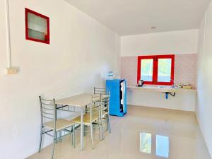 a dining room with a table and chairs and a refrigerator at The An Ant บ้านพัก&โฮมสเตย์ in Sam Roi Yot