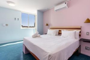 a bedroom with a large white bed with a window at The Tropicana Hotel in Cape Town +106 photos