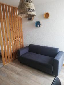 a blue couch in a living room with a chandelier at Lydia in Port Leucate