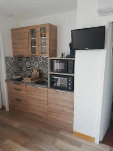 a kitchen with wooden cabinets and a microwave at Lydia in Port Leucate