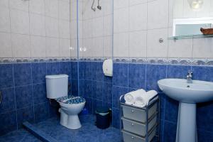a blue tiled bathroom with a toilet and a sink at Scotty's Boutique Hotel in Sofia