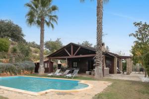 una casa con piscina y palmeras en Villa Ronda, en La Cimada