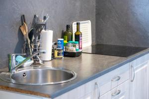 una encimera con fregadero y botellas de vino en L' Eclose Ty Gwen, en Le Guilvinec 20 fotos más