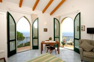 a room with a balcony with a table and chairs at La Dolce Vita Ravello - Studio Apartment with Breathtaking view of the Amalfi Coast in Ravello +3 photos