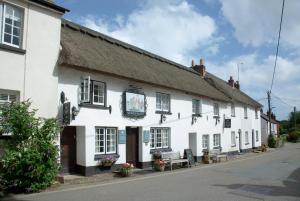 un bâtiment blanc avec un banc devant lui dans l'établissement Bakery Cottage, à East Budleigh