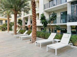 a row of chairs and palm trees in front of a building at Burj KHALIFA VIEW SMART HOME ZADA TOWER in Dubai