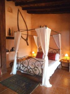 ein Schlafzimmer mit einem Bett mit Vorhängen darauf in der Unterkunft La Casa Mora in Jérica