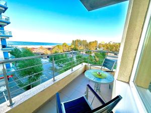 Un balcón con una mesa y sillas en un edificio. en Marcony Summerland Apartments, en Mamaia
