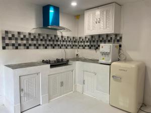 a kitchen with white cabinets and a refrigerator at Lucky Home Pool Villa Chiang Mai in Chiang Mai