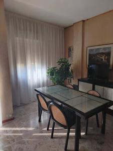 een eetkamer met een tafel, stoelen en een televisie bij L'attico di Ovidio 2 in Sulmona