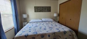 a bedroom with a bed with a blue floral bedspread at The Beach House in Hillsboro