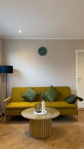 a living room with a yellow couch and a coffee table at Molenhuus Norddeich in Norddeich +41 photos
