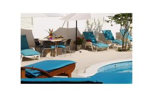 a pool with chairs and a table and an umbrella at Gorgeous Home In Neoric With Sauna in Neorić