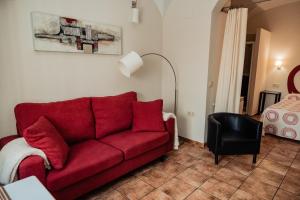 a living room with a red couch and a bed at Apartamento Las Avutardas 1 in Cáceres