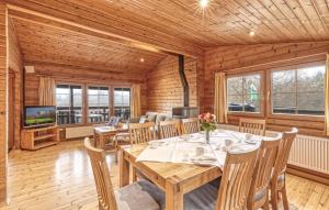 a dining room with a table and chairs and a television at Lovely Home In Masserberg With Wifi in Masserberg +9 photos