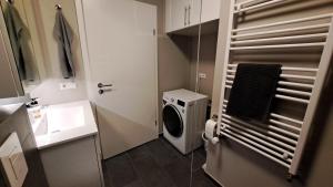 a bathroom with a washing machine and a sink at Central & cozy in Reykjavík +4 photos