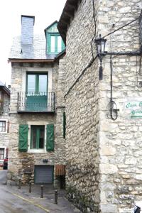 a stone building with a balcony on the side of it at Apartamentos Codallos in Tramacastilla de Tena