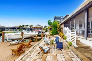 a patio with chairs and a boat on a marina at Lamplighter Cove in Marco Island