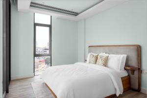Un dormitorio blanco con una cama grande y una ventana. en Carrara, en Lagos
