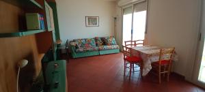 a living room with a table and a couch at Appartamento Giardino 4 in Ventimiglia