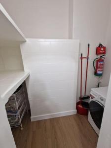 - une cuisine avec un mur blanc et une cuisinière dans l'établissement Apartamento en Arrigunaga, à Getxo