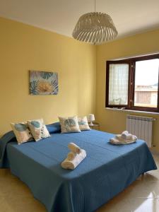 a bedroom with a blue bed with towels on it at Sicily Holiday Home in Termini Imerese