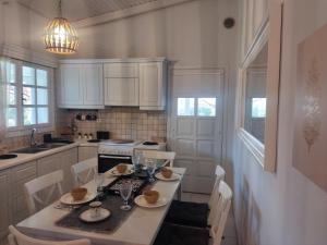 a kitchen with a table and chairs and a kitchen with white cabinets at A&V's Home in Agioi Apostoli