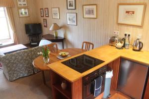 a kitchen and living room with a stove and a table at Glenfield in Lochailort